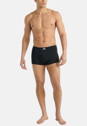 Schwarze Boxershorts aus Stretchstoff, mit enganliegendem Design und einem kontrastierenden weißen Logo am Bund. Weicher Stoff und mittellange Beine.