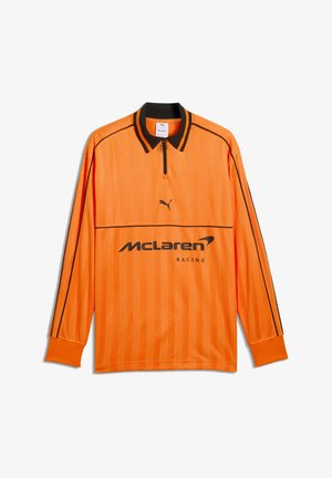 Pomarańczowa bluza McLaren Racing z długim rękawem, czarnym kołnierzem, czarnymi lamówkami na rękawach, czarnym logo Puma i zamkiem błyskawicznym z przodu.