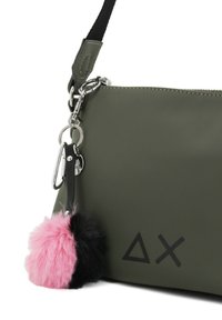 Borsa sintetica verde oliva con finitura testurizzata, caratterizzata da un charm pom-pom rosa e nero, hardware in argento e accenti del logo geometrico.