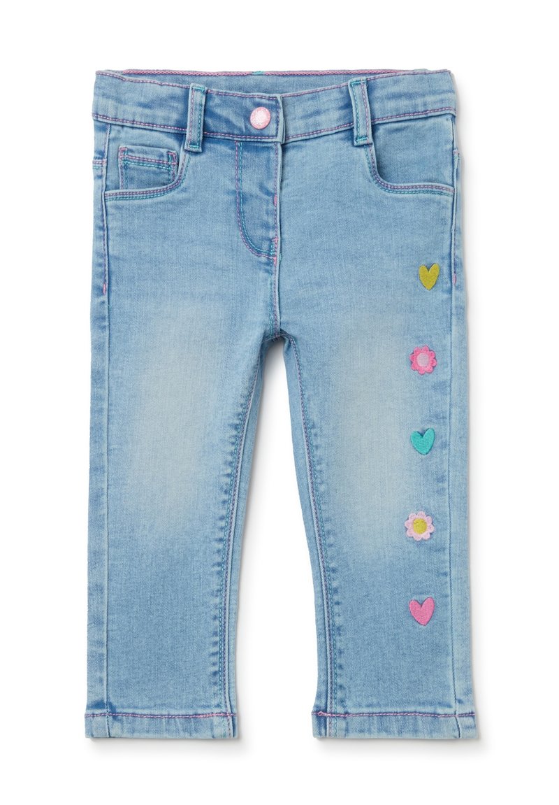 Pantalones de mezclilla azul claro con un acabado desgastado, que presentan aplicaciones coloridas de flores y corazones a lo largo de la pierna izquierda y acentos de costura rosa.