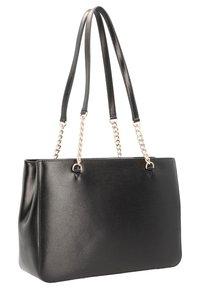 Sac fourre-tout en similicuir noir avec une forme structurée, deux longues anses et des accents en chaîne métallique. Texture lisse sans motifs visibles.