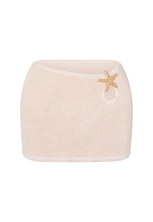Beige tekstureret miniskørt med en asymmetrisk talje og en dekorativ gul søstar accent nær den øverste højre side.