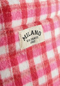Roosa ja valge ruuduline villakangas, millel on tekstureeritud pind; sisaldab sildit, millel on kiri "MILANO VIA DANTE 1982."