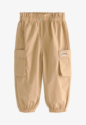 Pantalon cargo beige pour enfants avec taille et poignets élastiques, poches à rabat latérales et un patch arc-en-ciel sur le rabat de la poche droite.