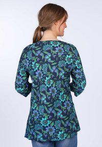 Long-sleeve top with a navy background, featuring a floral pattern in turquoise, green, and burgundy. Tunic-style with side slits.