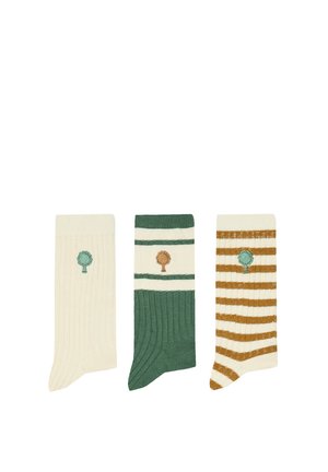 Trois chaussettes côtelées présentées côte à côte : crème avec un arbre vert, verte avec des rayures crème et un arbre marron, crème avec des rayures marron et un arbre vert.
