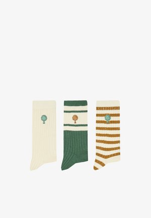 Trois chaussettes côtelées présentées côte à côte : crème avec un arbre vert, verte avec des rayures crème et un arbre marron, crème avec des rayures marron et un arbre vert.