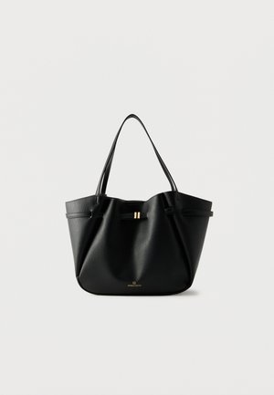 Sac cabas en cuir noir avec deux bretelles, un petit fermoir doré et le logo "Anna Field" sur fond blanc.