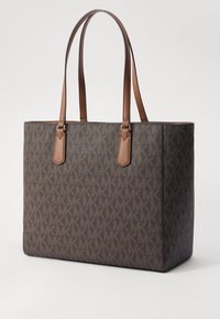 Sac fourre-tout marron avec motif monogramme MK, garniture en cuir et deux poignées. Forme rectangulaire avec un design structuré et texture lisse.