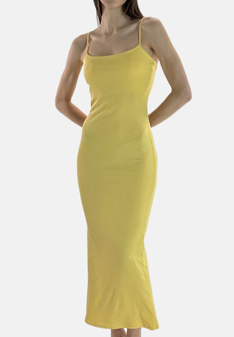 Gele midi-jurk met geribbelde structuur, dunne bandjes, aansluitende pasvorm en een gladde textuur, eindigend halverwege de kuit. Minimalistisch ontwerp zonder patronen.