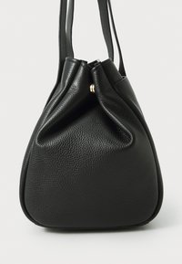Sac à main en cuir noir avec une finition douce et texturée. Il présente un design collecté en haut, des doubles poignées et une petite accent en métal doré.