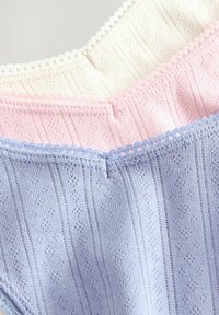 Three textured fabric pieces in white, pink, and light blue, featuring ribbed patterns and scalloped trim along the edges.
