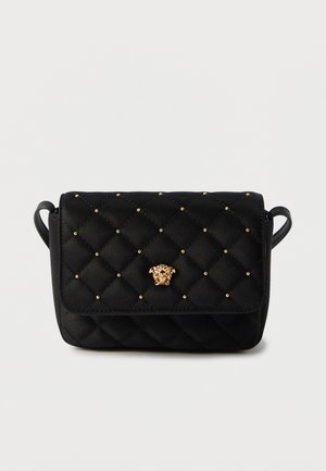Black quilted handbag with gold studs and a gold lion head emblem on the front. Features a flap closure and a detachable strap.