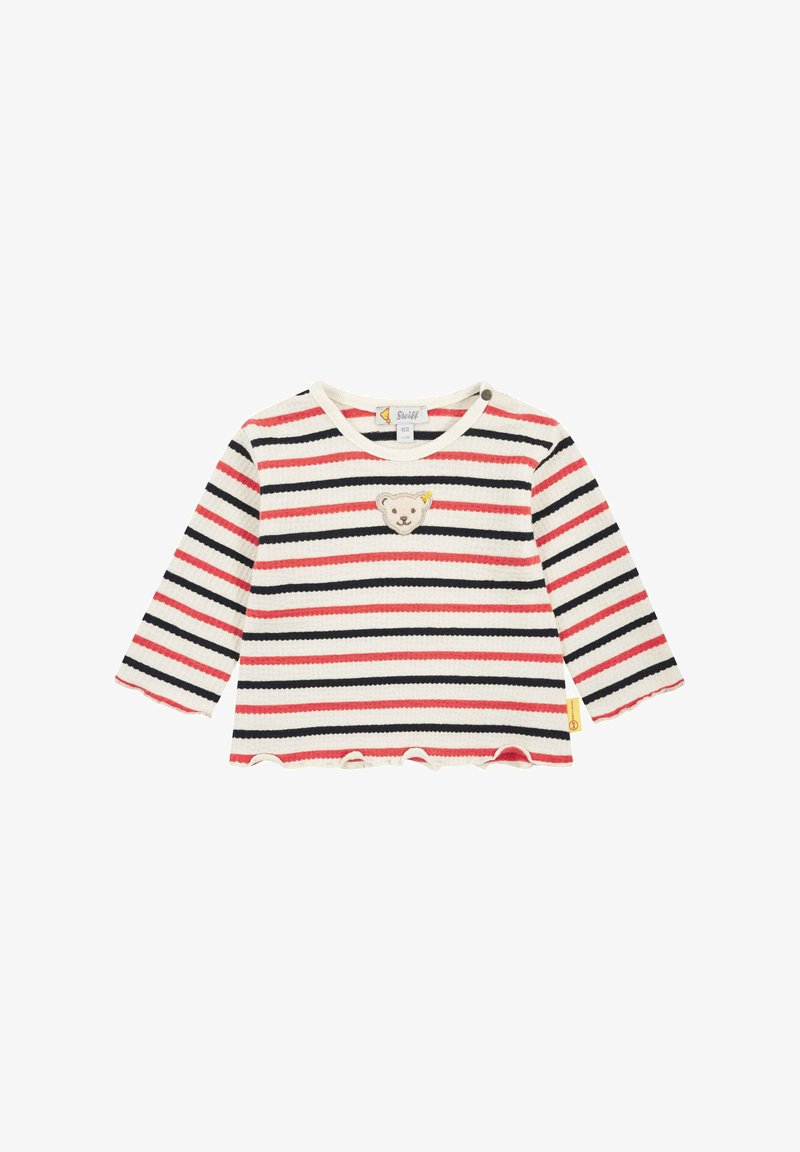Striped long-sleeve top in white, red, and navy. Features a bear patch on the chest and a scalloped hem. Made of textured fabric.