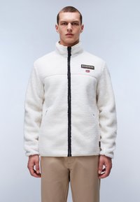 Weiße Fleecejacke mit hohem Kragen, schwarzem Reißverschluss und Logo-Patch. Verfügt über strukturierten Stoff und seitliche Taschen.