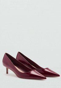 Burgundy patent leather pumps with a pointed toe and a small, conical heel. Smooth texture with a sleek, minimalist design.