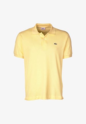 Żółta koszulka polo wykonana z bawełny, z dwiema guzikami przy dekolcie, krótkimi rękawami oraz małym czarnym logo krokodyla na piersi.