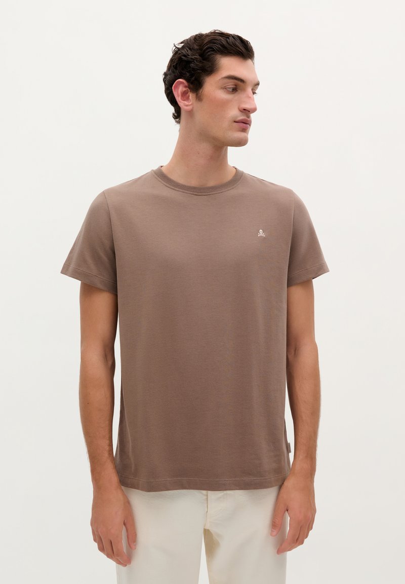 Korte bruine t-shirt met korte mouwen in zachte stof, met een ronde halslijn en een klein logo detail op de borst.