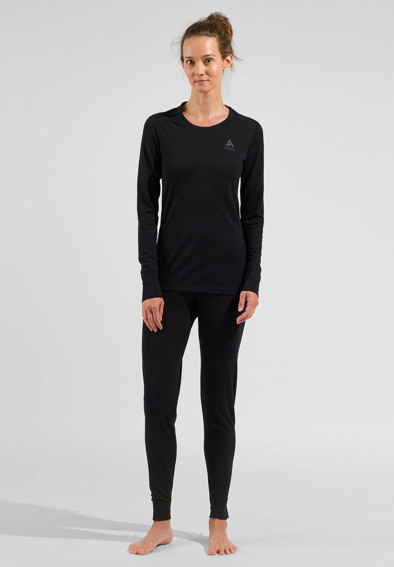 Black long-sleeve top and matching leggings made of a smooth, stretchy fabric. Features a round neckline and logo detail on the chest.