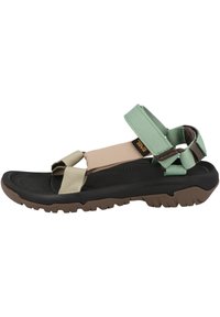 Adjustable multi-strap sandals featuring green, beige, and black materials. Textured rubber sole with traction pattern. Lightweight design.