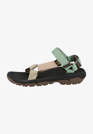 Adjustable multi-strap sandals featuring green, beige, and black materials. Textured rubber sole with traction pattern. Lightweight design.