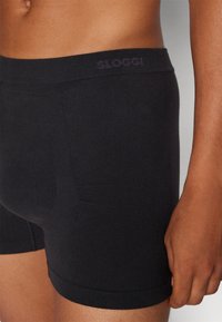 Schwarze Baumwoll-Boxershorts mit einer körpernahen Passform, ausgestattet mit einem weichen Bund mit "SLOGGI"-Logo und glatter Textur.