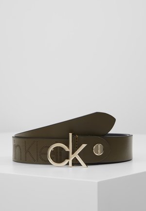 Donkerbruine leren riem met geperforeerd Calvin Klein-logo en gouden metalen gesp in de vorm van in elkaar grijpende "ck" letters.