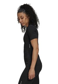 Black athletic t-shirt with a fitted design, short sleeves, and a textured fabric. Features a white logo on the side.