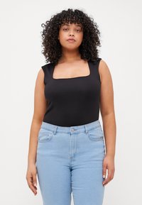 Bodysuit negro sin mangas con escote cuadrado, combinado con jeans de tiro alto de color azul claro. Tejido suave y diseño ajustado.