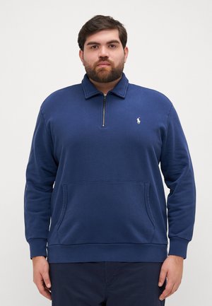 Granatowy sweter z kapturem, zapinany na zamek, z długimi rękawami, kieszenią z przodu oraz małym haftowanym logo na piersi. Miękki materiał.