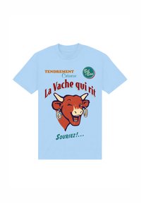 Světle modré bavlněné tričko s grafikou usmívající se krávy s naušnicemi. Text zní "La Vache qui rit" s dekorativními prvky.