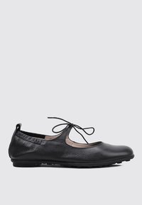 Bailarinas negras de cuero con punta redondeada, detalle de cordones y un acabado texturizado. Cuentan con una suela de goma baja para mayor flexibilidad.