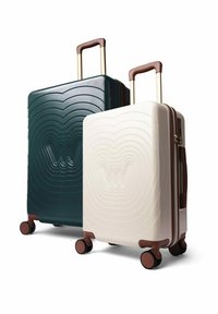 Sada tvrdého zavazadla v tmavě zelené a krémové barvě. Obsahuje design vlnového vzoru, teleskopické rukojeti a čtyři černé kolečka s hnědými akcenty.