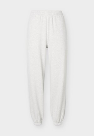 Lichtgrijze sweatpants met elastische tailleband en enkelmouwen, plat uitgestald op een witte achtergrond.