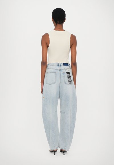 Lichtblauwe, loszittende denim jeans met een hoge taille, vier zakken en een patch met bedrukte tekst op de achterkant. Gladde stofstructuur.