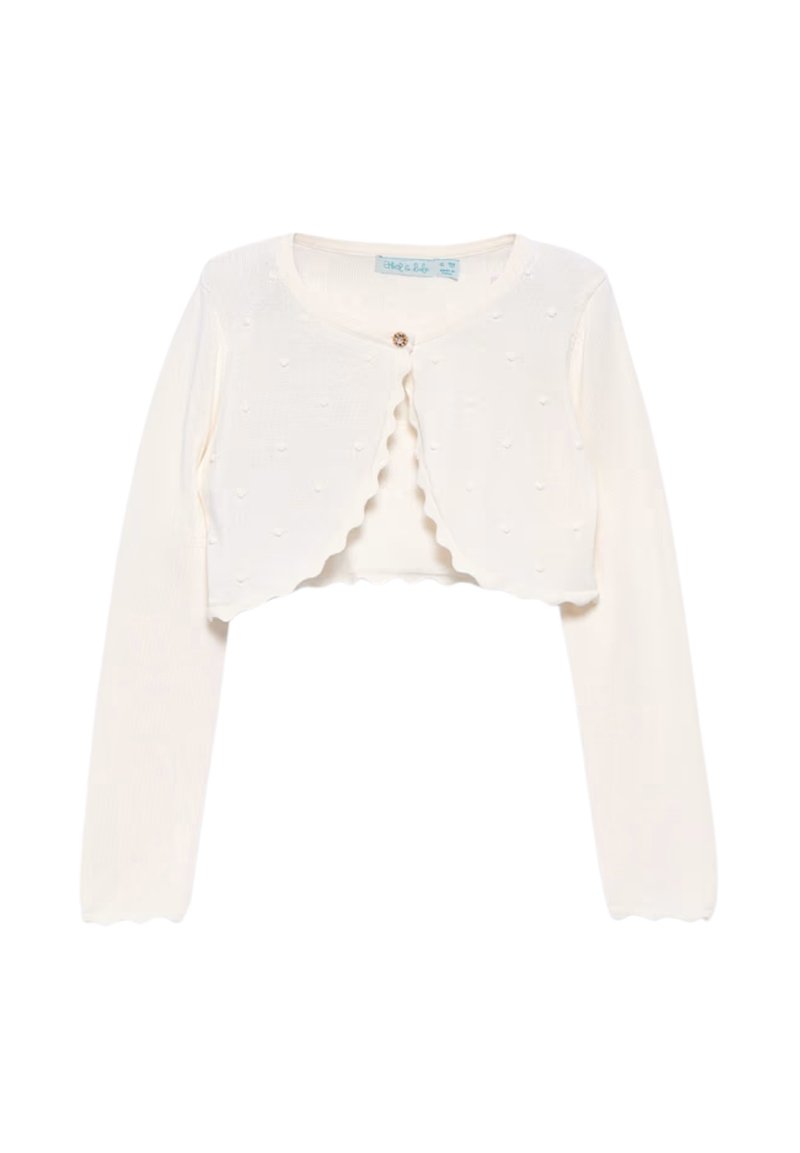 Cardigan bianco corto con maniche lunghe, texture a coste, bordi ondulati e piccoli dettagli a forma di cuore. Chiusura con un bottone centrale.