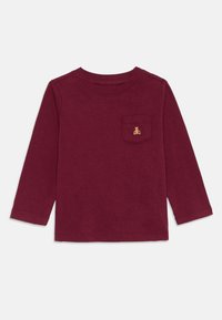 Langermet burgunder skjorte laget av myk bomull, med en brystlomme med en liten brodert bjørnedesign. Jevn tekstur, rund hals.