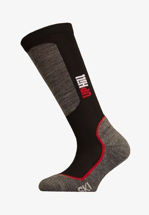 Schwarze und graue kniehohe Socke mit roten Akzenten, ausgestattet mit einem strukturierten Bund und verstärktem Fersenbereich. Der obere Teil zeigt ein Logo in Weiß und Rot.