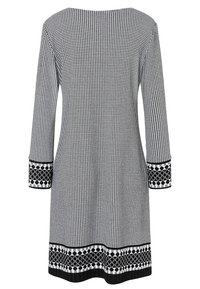 Schwarz-weißer karierter Kleid mit langen Ärmeln, weitem Ausschnitt und strukturierten schwarzen und weißen gemusterten Bündchen und Saum.