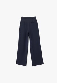 Pantalons larges de couleur marine en tissu lisse. Présentent une taille, un devant plat et une poche arrière, avec un design épuré et minimaliste.