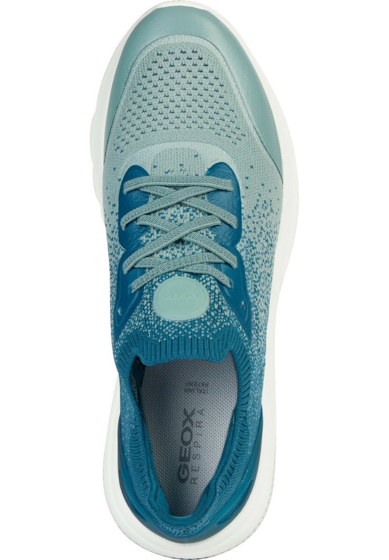 Zapatilla deportiva de color azul claro con parte superior de tejido texturizado, acentos reforzados, cordones en tono y suela de goma blanca. Presenta el logo en el talón.