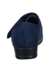 Scarpa blu navy con tomaia in morbido tessuto, tacco arrotondato e colletto imbottito. Suola in gomma nera con finitura texturizzata e senza schemi o elementi metallici visibili.