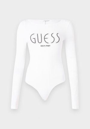 Body bianco a maniche lunghe con scollatura rotonda. Presenta il logo "GUESS" e "EST.1981" stampati in nero sul davanti. Texture liscia.