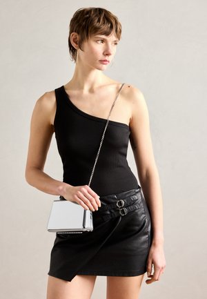 Sort en-skulder ribbet tanktop parret med en sort læder miniskirt med en spændeaccent; holder en skinnende rektangulær metallisk taske.