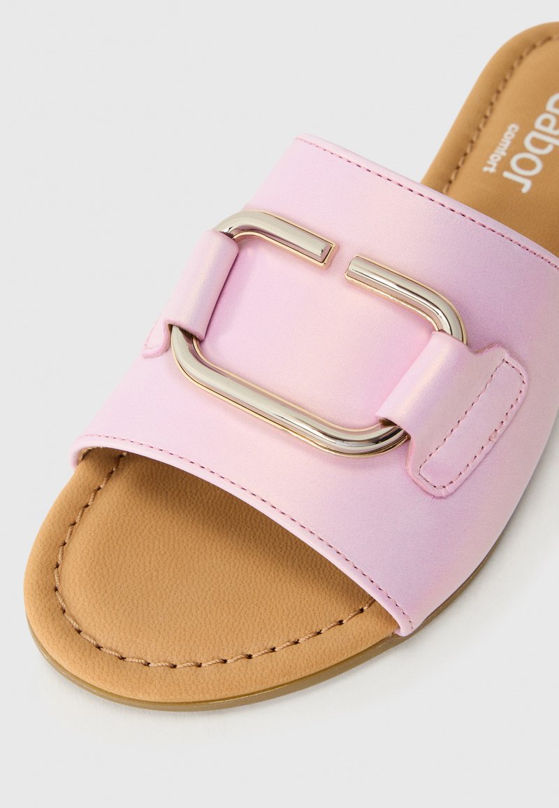 Helle rosa Rutschsandale mit einer großen metallischen Schnalle, einem braunen Fußbett und sichtbaren Nähten an der Sohle.