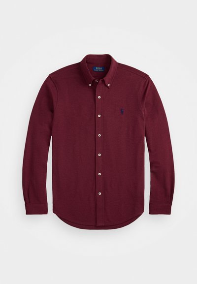 Μπορντό μακρυμάνικη πουκαμίσα με κουμπιά από βαμβάκι, που έχει κοφτή γιακά, στρογγυλή αφετηρία και ένα μικρό κεντητό λογότυπο στο στήθος.
