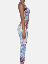 Wielokolorowy zestaw topu i legginsów z żywym abstrakcyjnym wzorem, wykonany z gładkiego, elastycznego materiału i dopasowanym krojem.