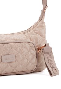 Borsa a spalla in nylon beige trapuntato con tasca frontale, tracolla testurizzata e accessori in metallo dorato con etichetta del brand in rilievo.
