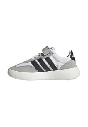 Sneaker grigia e bianca con una tomaia in suede texture e sintetico liscio, caratterizzata da tre strisce nere, chiusura a lacci e collare imbottito.