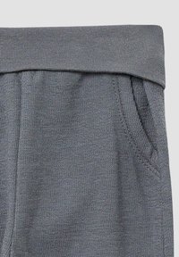 Grau elastischer Bund aus strukturiertem Stoff, mit seitlichen Taschen und einem weichen, dehnbaren Material, das ideal für Komfort und Bewegungsfreiheit ist.